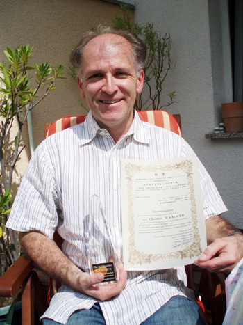 音楽総監督就任の証書と記念品を手にするクリスティアン・ハンマー